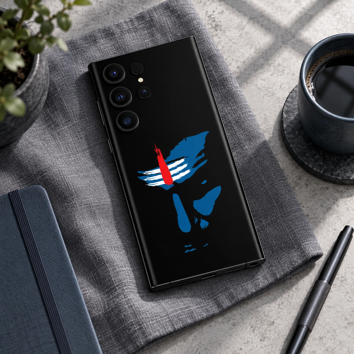 Mahadev Blue Face Mobile Skin - linen flat lay Mahadev black mobile skin with blue Shiva stencil on grey linen in a modern flat lay