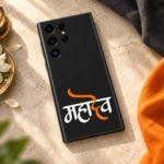 Mahadev orange calligraphy mobile skin with white Hindi lettering on black – linen flat lay
