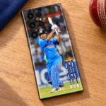MS Dhoni batting photo mobile skin, oak desk flat lay with cricket ball