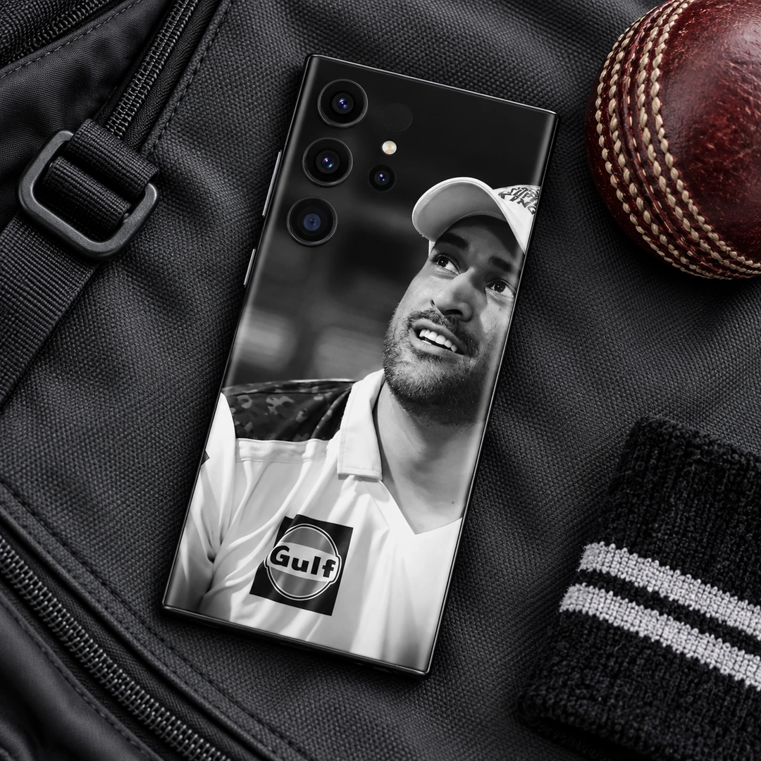 MS Dhoni Black and White Portrait Mobile Skin – Cricket bag flat lay MS Dhoni Black and White Portrait Mobile Skin, cricket bag flat lay showing the original smiling portrait and cap