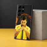 MS Dhoni photo mobile skin with yellow jersey portrait and orange lion artwork, yellow studio angle