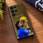 MS Dhoni photo mobile skin with blue jersey and yellow helmet, walnut desk lifestyle