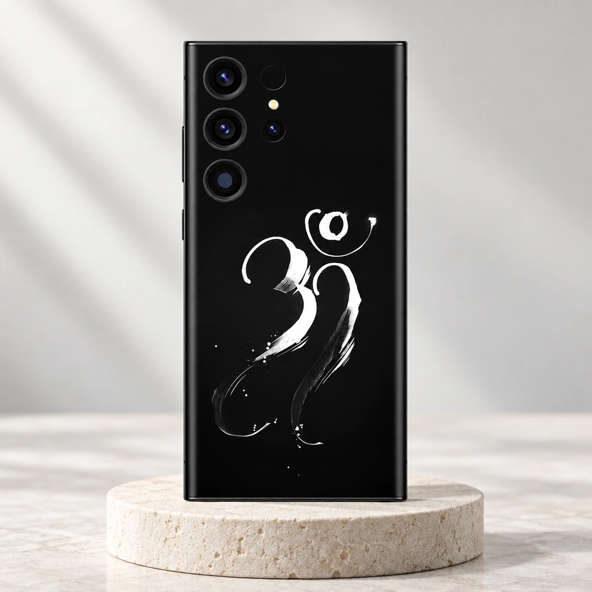 Om Mahadev White Calligraphy Mobile Skin - Ivory hero Om Mahadev mobile skin with white brush calligraphy on black displayed on an ivory pedestal