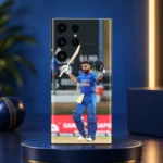 Virat Kohli mobile skin showing a raised bat and helmet celebration in blue India uniform, navy studio hero