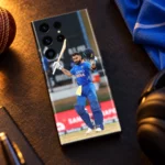 Virat Kohli mobile skin showing a raised bat and helmet celebration in blue India uniform, evening sports desk