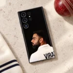 Virat Kohli black portrait mobile skin lying on pale stone beside a red cricket ball