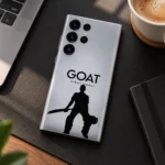 Silver-gray Virat Kohli GOAT mobile skin with black cricketer silhouette, minimal desk view