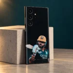 Virat Kohli mobile skin with gold helmet and bat portrait on black, stone studio angle