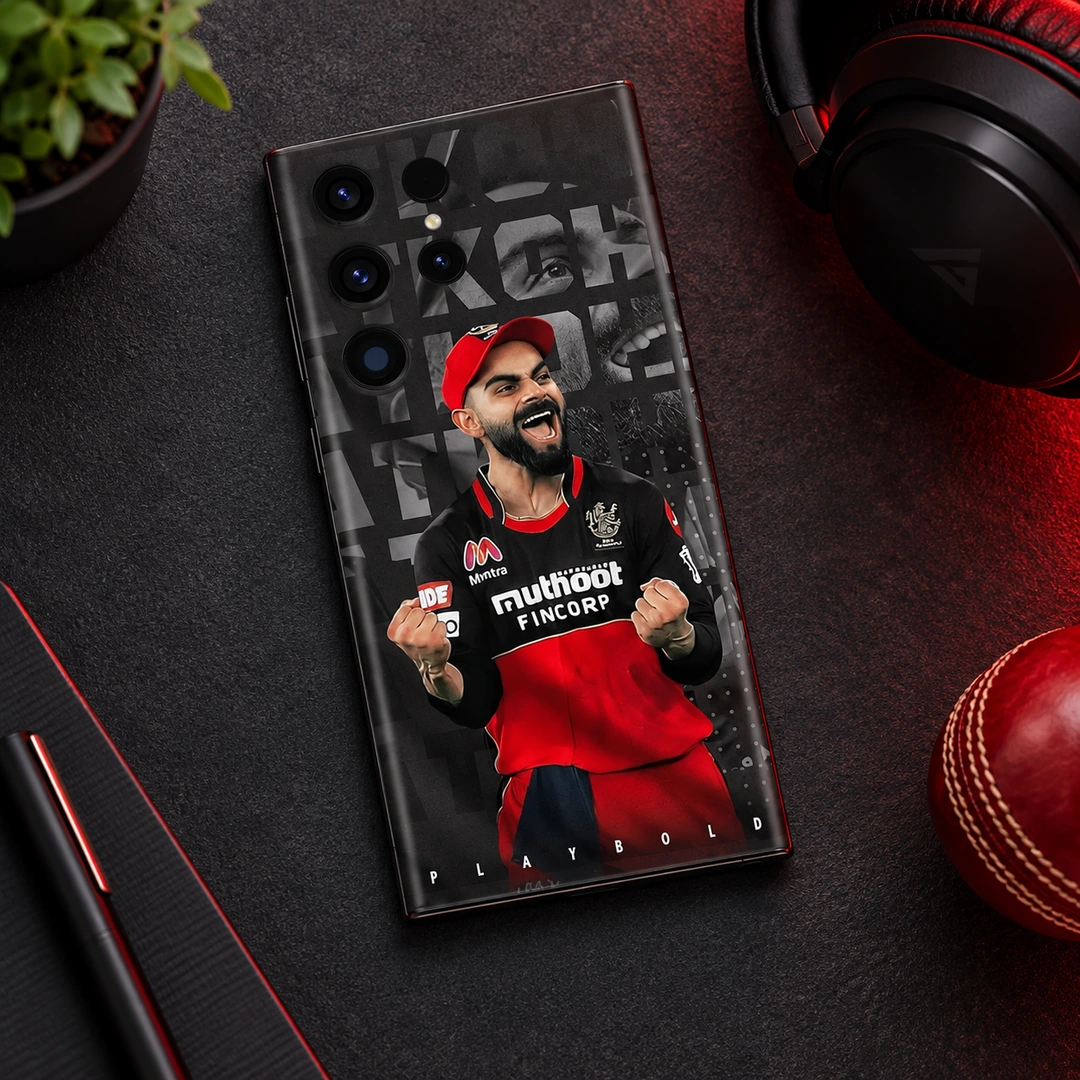 Virat Kohli Play Bold Mobile Skin – Dark desk flat lay Virat Kohli red and black Play Bold mobile skin, dark desk flat lay