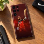 Virat Kohli raised-bat photo mobile skin in red and black, walnut desk lifestyle