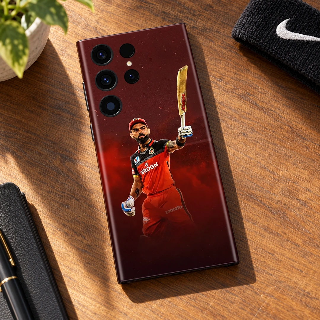 Virat Kohli Raised Bat Photo Mobile Skin - walnut desk lifestyle Virat Kohli raised-bat photo mobile skin in red and black, walnut desk lifestyle
