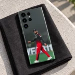 Virat Kohli walking in red and black cricket kit on a phone skin, black canvas lifestyle