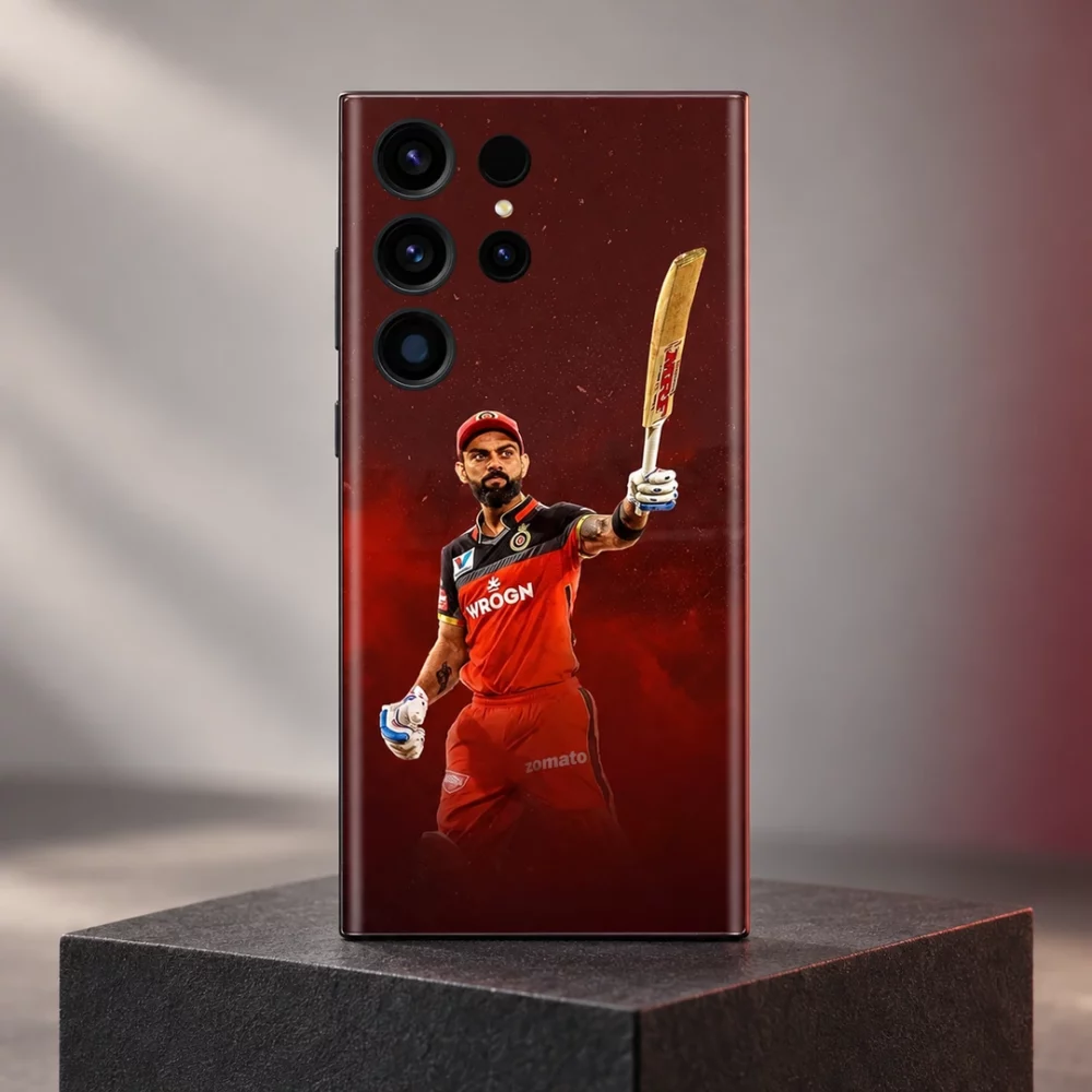Virat Kohli mobile skin with raised bat and red cricket kit against burgundy, charcoal plinth hero