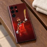 Virat Kohli mobile skin with raised bat and red cricket kit against burgundy, walnut bench view
