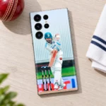 Virat Kohli batting in white Test uniform on a mobile skin, cricket desk flat lay view