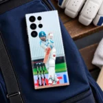 Virat Kohli batting in white Test uniform on a mobile skin, sports bag view