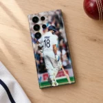 Virat Kohli photo mobile skin with VIRAT 18 on white cricket kit, oak desk flat lay