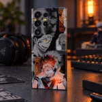 Sukuna mobile skin with gray manga collage and orange Japanese lettering, night desk angle