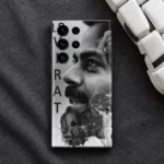 Virat Kohli monochrome collage mobile skin on dark fabric beside a white cricket glove