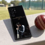 Black Virat Kohli mobile skin with gold 1% chance quote and seated portrait, cricket ground view