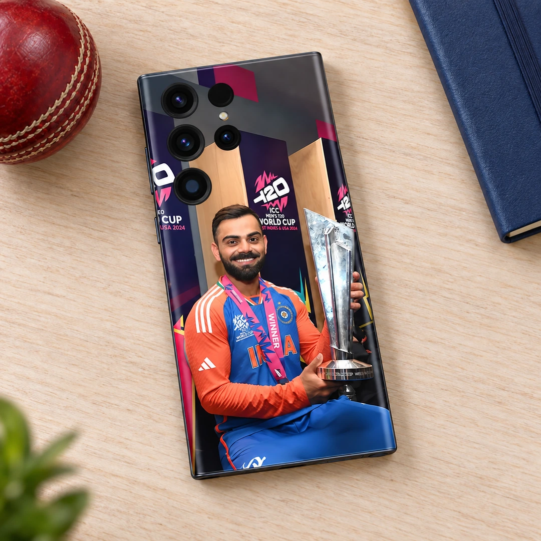 Virat Kohli T20 Trophy Mobile Skin – cricket desk Virat Kohli T20 trophy mobile skin on a wooden desk beside a cricket ball