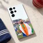 Virat Kohli trophy mobile skin lying on pale stone beside a red cricket ball