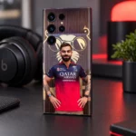 Virat Kohli mobile skin with red jersey portrait and gold lion backdrop, dark desk angle