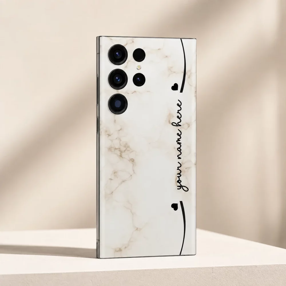 Elegant Marble Customized Name Mobile Skin — angled view showing cream marble with black hearts and custom cursive name