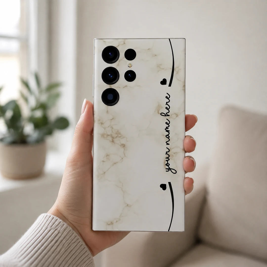 Elegant Marble Customized Name Mobile Skin - in hand Elegant Marble Customized Name Mobile Skin — in hand showing cream marble with black hearts and custom cursive name
