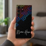 Neon Maze Customized Name Mobile Skin — in hand showing rainbow neon maze lines on black with white cursive sample name
