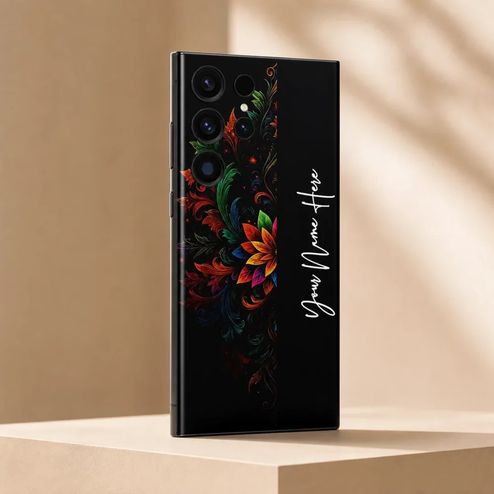 Royal Floral Glow Customized Name Mobile Skin — angled view showing colourful floral scrollwork on black with vertical white cursive sample name