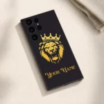 Royal Lion Crown Customized Name Mobile Skin — flat lay showing a gold crowned lion on charcoal with ornate gold sample name lettering