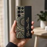 Royal Mandala Customized Name Mobile Skin — in hand showing the black and gold mandala design with gold cursive sample name
