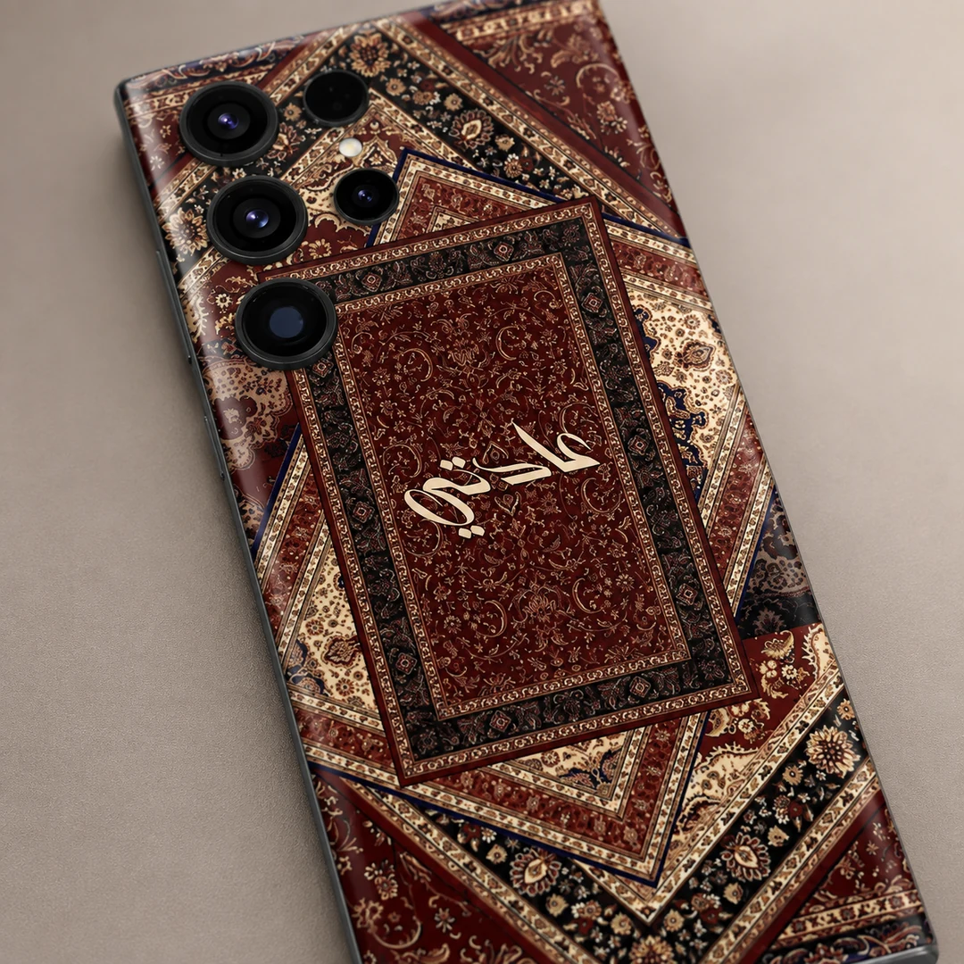 Sultan’s Grace Custom Name Mobile Skin - name detail Sultan’s Grace Custom Name Mobile Skin — name detail showing burgundy, cream and black Persian rug motifs with central cream calligraphy