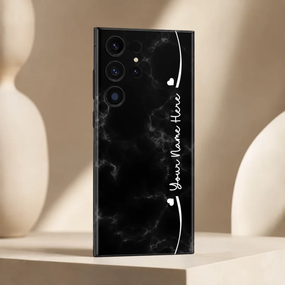 Black Marble Custom Name Mobile Skin — angled view showing black marble with subtle grey veins, white hearts and cursive sample name