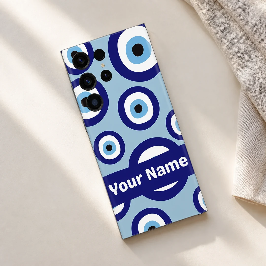 Evil Eye Custom Name Mobile Skin - Flat Lay Evil Eye Custom Name Mobile Skin shown diagonally on a cream surface beside neutral linen