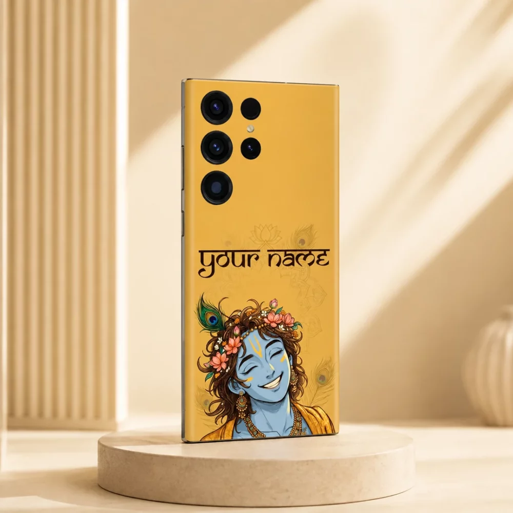 Lord Krishna Custom Name Mobile Skin — angled view showing smiling blue Krishna with flowers and peacock feather on mustard yellow, plus sample name