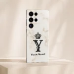 Royal White Marble Custom Name Mobile Skin — angled view showing white marble with a black crown, Y monogram and sample name