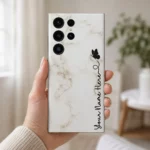 White Marble Butterfly Custom Name Mobile Skin — in hand showing white marble with a black butterfly and vertical cursive personalised name
